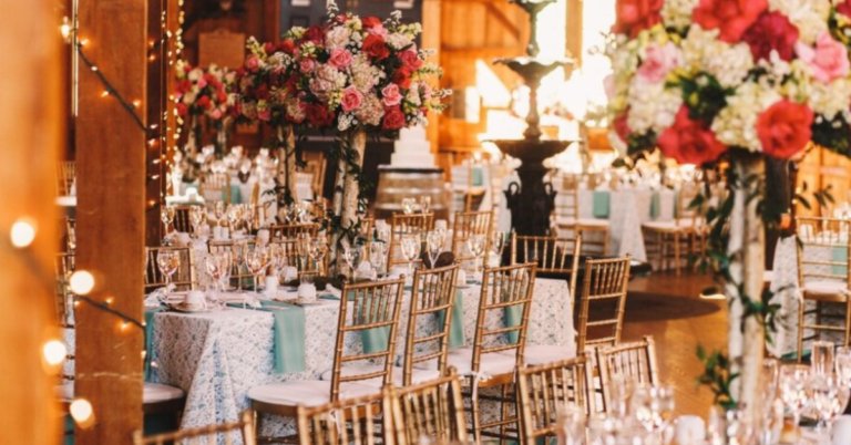 Elegant wedding reception centerpiece with candles and flowers on a beautifully decorated table.